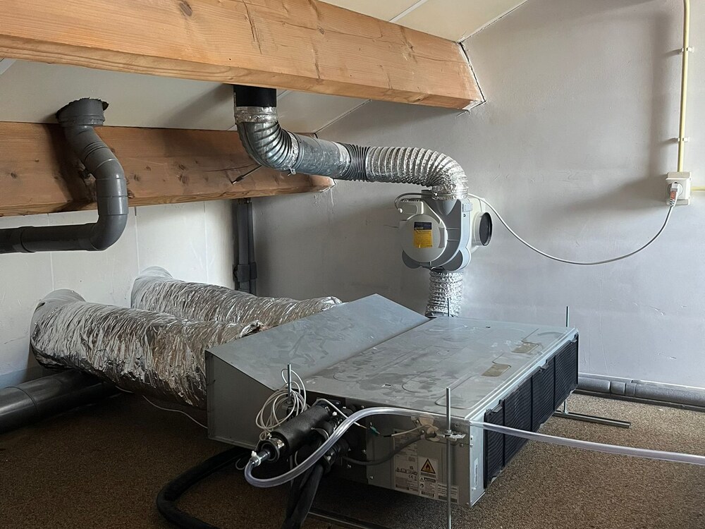Nette technische installatie van een aircosysteem op zolder